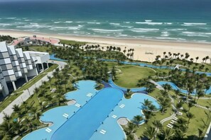 A resort with a large swimming pool, a beach, and a modern building. - The Arenam Cam Ranh Nha Trang Resort (Cam Ranh)