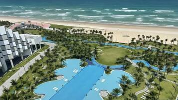 Un resort con una amplia piscina, acceso a la playa y un edificio moderno.