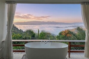 Une baignoire dans une pièce offrant une vue sur un paysage montagneux.