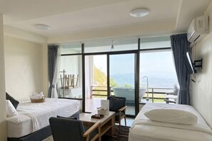 A hotel room with two beds, a desk, and a balcony with a view. - Masora Doichang (Mae Suai)