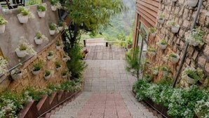 A staircase with potted plants on both sides, leading to a wooden deck. - Michelia Valley Hotel (Dalat)