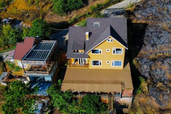 A multi-story house with a large roof, a visible garage, and a swimming pool. - Michelia Valley Hotel (Dalat)