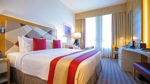 A hotel room with a large bed, a desk, a chair, and a window with curtains. - Gulf Inn Hotel Al Nasr, Bur Dubai (Dubai)