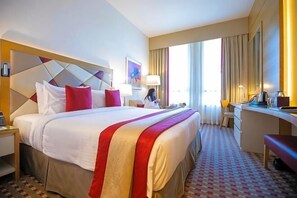 A hotel room with a large bed, a desk, a chair, and a window with curtains. - Gulf Inn Hotel Al Nasr, Bur Dubai (Dubai)