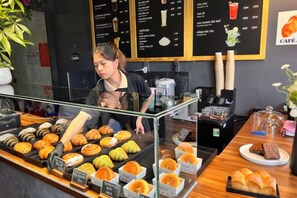 A bakery display with various pastries and a menu board in the background.