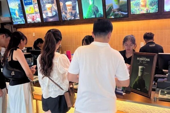 A restaurant interior with a counter, menu boards, and staff uniforms.