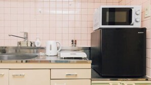 A kitchen with a microwave, toaster, and refrigerator. - Nippombashi Back Kuromon AFP Apartment (Osaka)