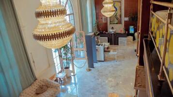 A spacious living area with a large chandelier, a sofa, and a dining table.