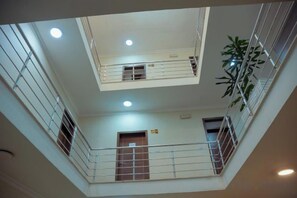 A multi-level interior with balconies, railings, and a plant. - BOYUE Hotel (Addis Ababa)