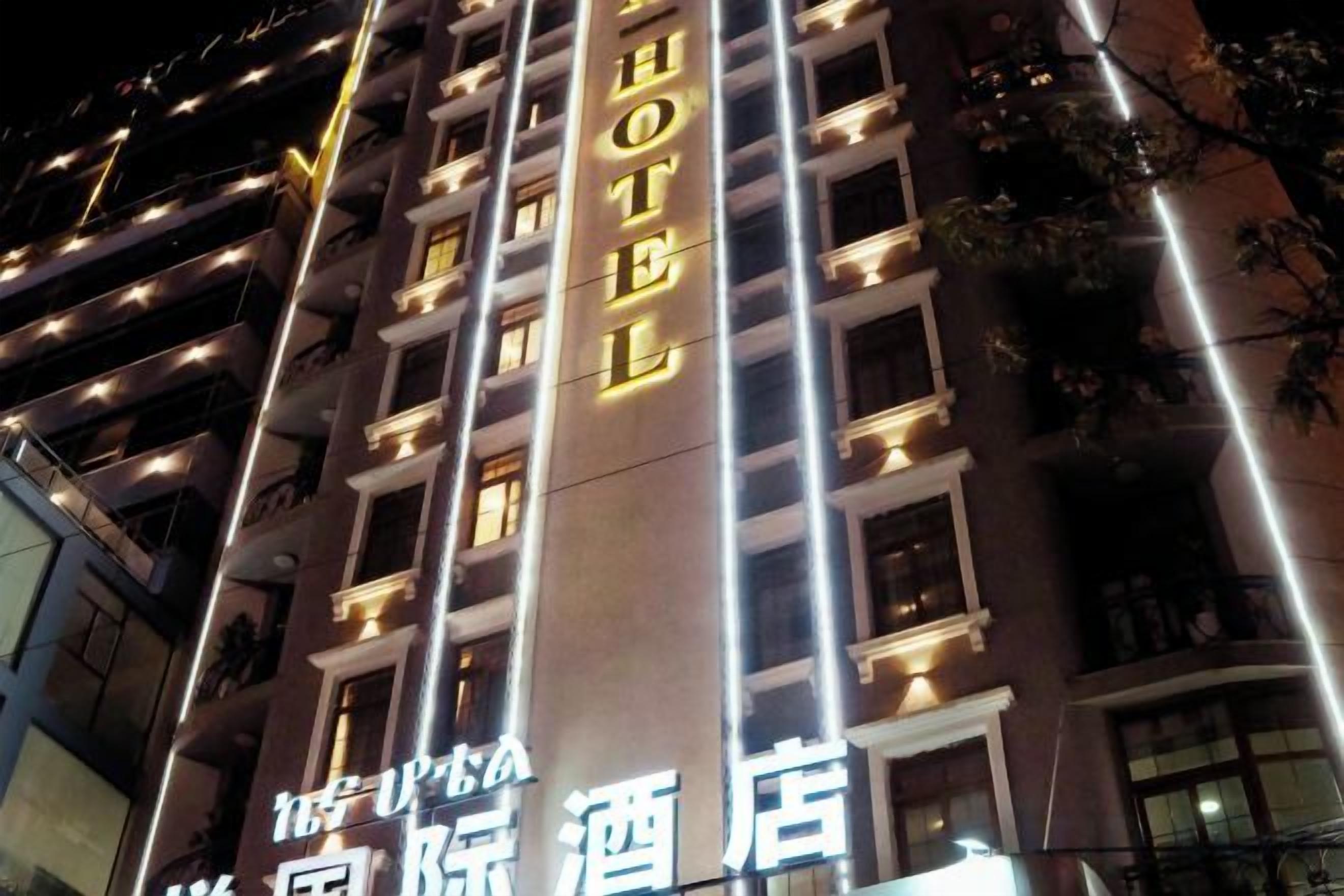 Un hotel con señalización iluminada, varios pisos y un diseño arquitectónico moderno.