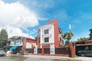 Ein Gebäude mit roter und weißer Fassade, einem verschlossenen Eingang und blauem Himmel.