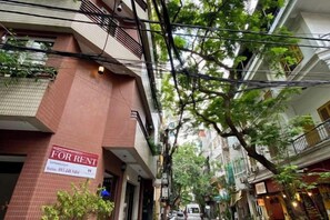 A narrow street with a building marked 'For Rent' on the left.