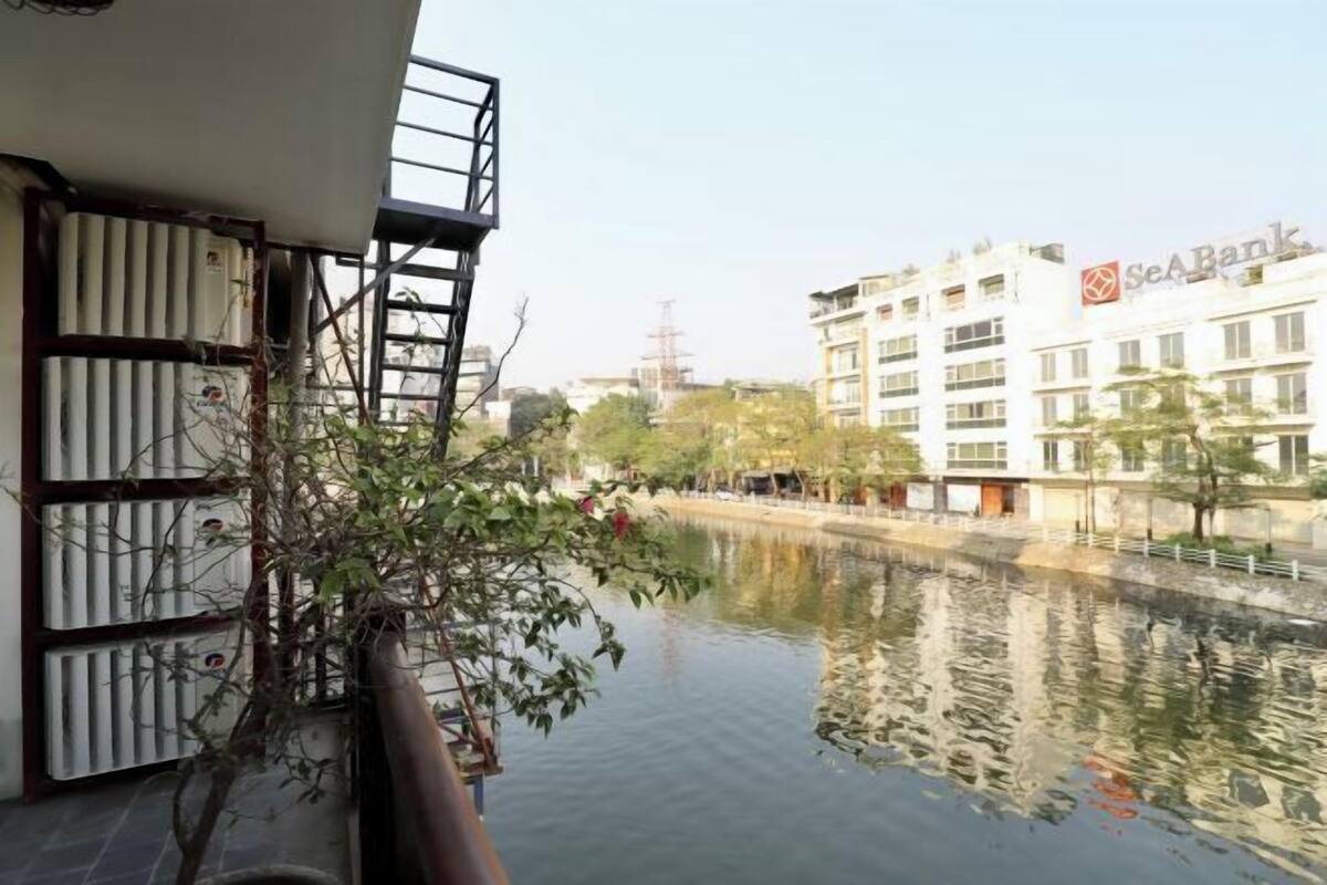 Un río con edificios al fondo, incluyendo un banco con un letrero.