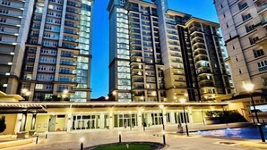 A high-rise hotel with multiple floors, a well-lit entrance, and a central courtyard. - Kuching City Center Riverine Apartment With Balcony & City Views (Kuching)