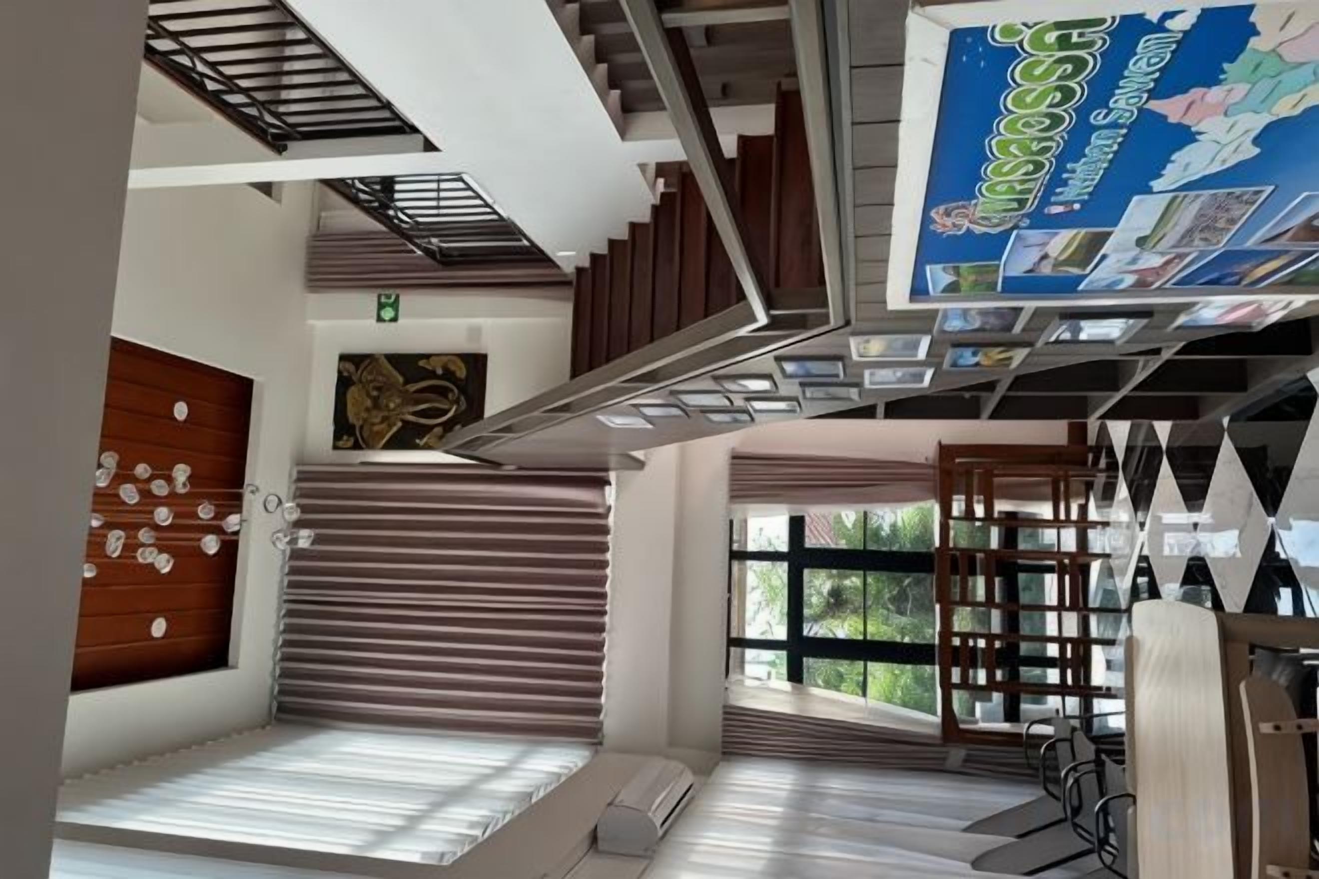 Ein modernes Hotelinnere mit einer Treppe, einer Sitzecke und einem großen Fenster.