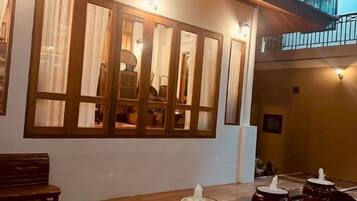 A room with a large window, a bench, and a table with decorative items.