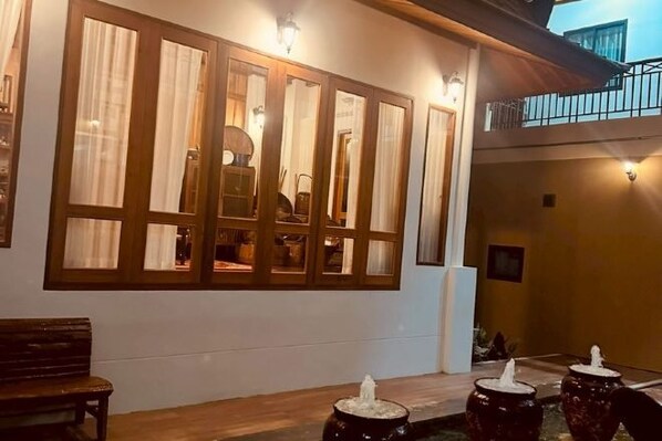 A room with a large window, a bench, and a table with decorative items.