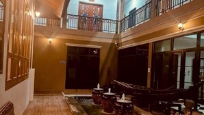 Un'accogliente hall d'albergo con pavimento in legno, un elemento decorativo a base d'acqua e un balcone.