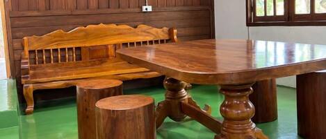 A wooden bench and a round table with a central pedestal base.