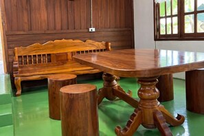 Un banc en bois et une table ronde dotée d’un pied central.
