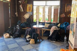 Une pièce contenant plusieurs sacs, une table et un banc.