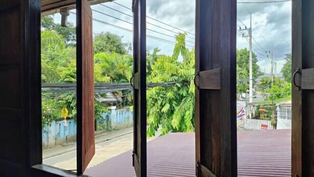 A room with a view of a street and greenery outside. - Baanpai Hostel (Pai)