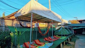 A covered outdoor area with hammocks and lounge chairs. - Baanpai Hostel (Pai)