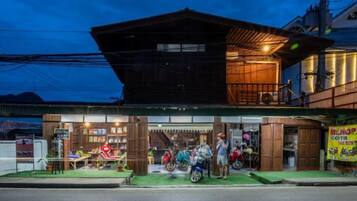Un edificio de dos pisos con fachada de madera y un balcón.