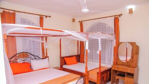 A bedroom with three single beds, each with a canopy. There is a wooden dresser with a mirror and a small table. - Tremendous 4-bedroom bungalow in Kilifi County (Kilifi County)