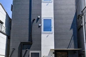 A building with a grey facade, a small window, and a door. - HOTEL AZUMA SEE (Tokyo)