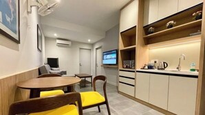 A compact hotel room with a dining area, kitchenette, and a television. - LV Modern Suite Langkawi by Zervin (Langkawi)