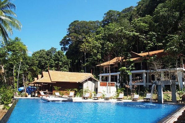 A swimming pool with lounge chairs and a building with a red roof. - D'Coconut Lagoon (Pulau Lang Tengah)