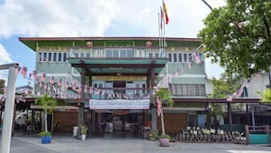 A hotel with a green facade, a balcony with flags, and a sign reading "PULAU KETAM INN".