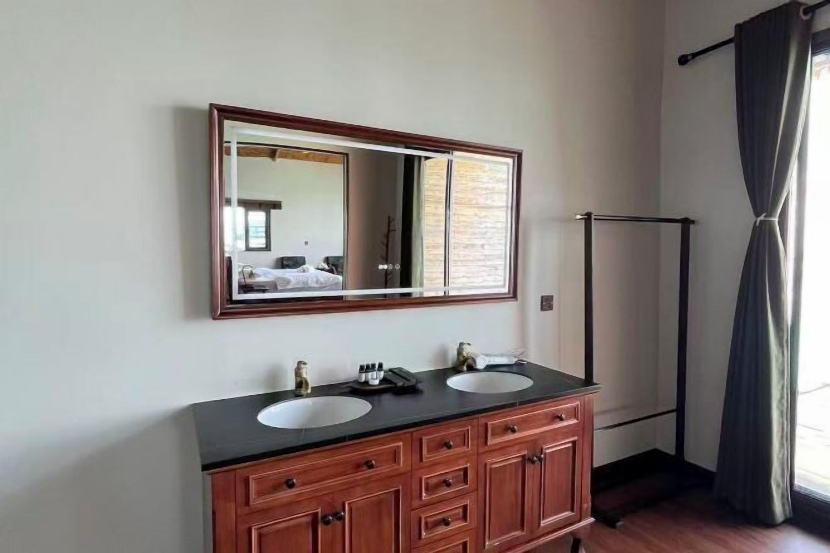 A bathroom with two sinks, a large mirror, and a towel rack.