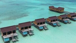 Overwater bungalows with wooden structures and blue swimming pools, connected by walkways over clear turquoise water. - Moana Water Village Semporna (Semporna)