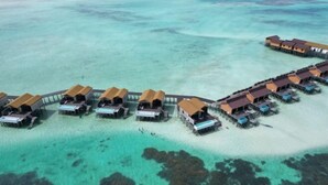 An aerial view of overwater bungalows with clear turquoise water and rocky seabed. - Moana Water Village Semporna (Semporna)