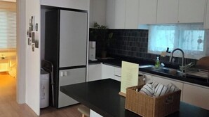 Una cocina moderna con armarios blancos, una encimera negra y un ventanal con vistas.