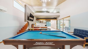 A pool table labeled 'SuperStar' in a modern room with a kitchen, dining area, and a staircase leading to an upper level. - Beyand Private Pool Villa Pension, Daebu (Ansan)