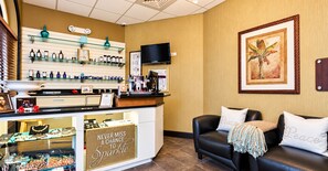 A reception area with a counter displaying various products, a television, and a framed artwork on the wall.