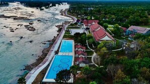 Vista aérea de un resort con piscina, playa y un camino que lleva a la playa.