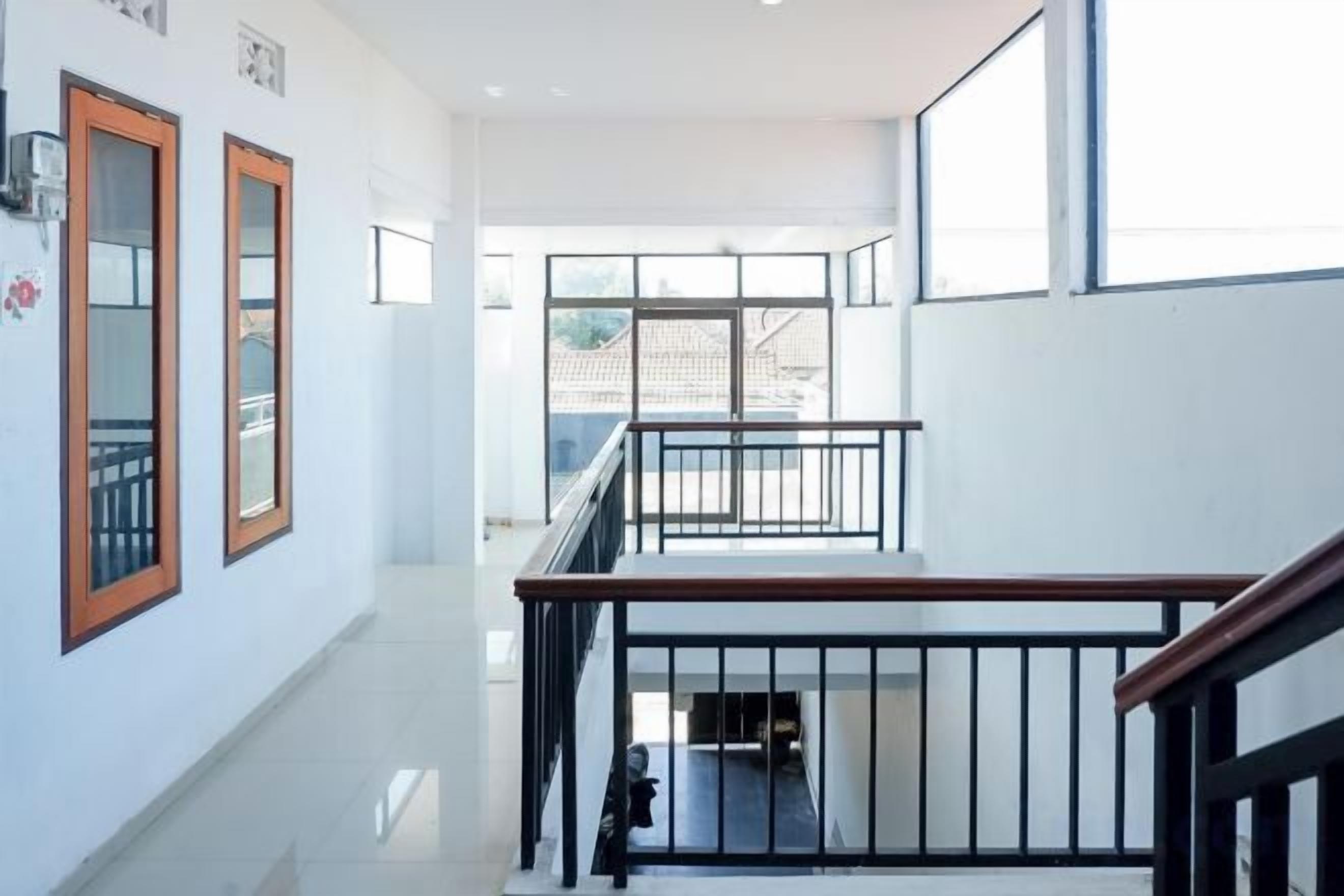A multi-level interior with a staircase, railings, and a view to the outside.