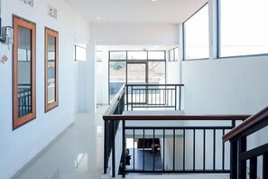 A multi-level interior with a staircase, railings, and a view to the outside. - KoolKost near Raya Canggu (Minimum Stay 5 Nights) (Bali)