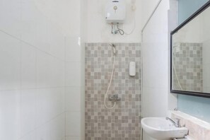 A bathroom with a tiled shower wall, a sink, and a mirror. - KoolKost near Raya Canggu (Minimum Stay 5 Nights) (Bali)