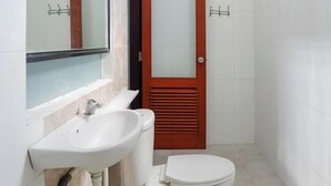 A bathroom with a white sink, a toilet, and a mirror. - KoolKost near Raya Canggu (Minimum Stay 5 Nights) (Bali)