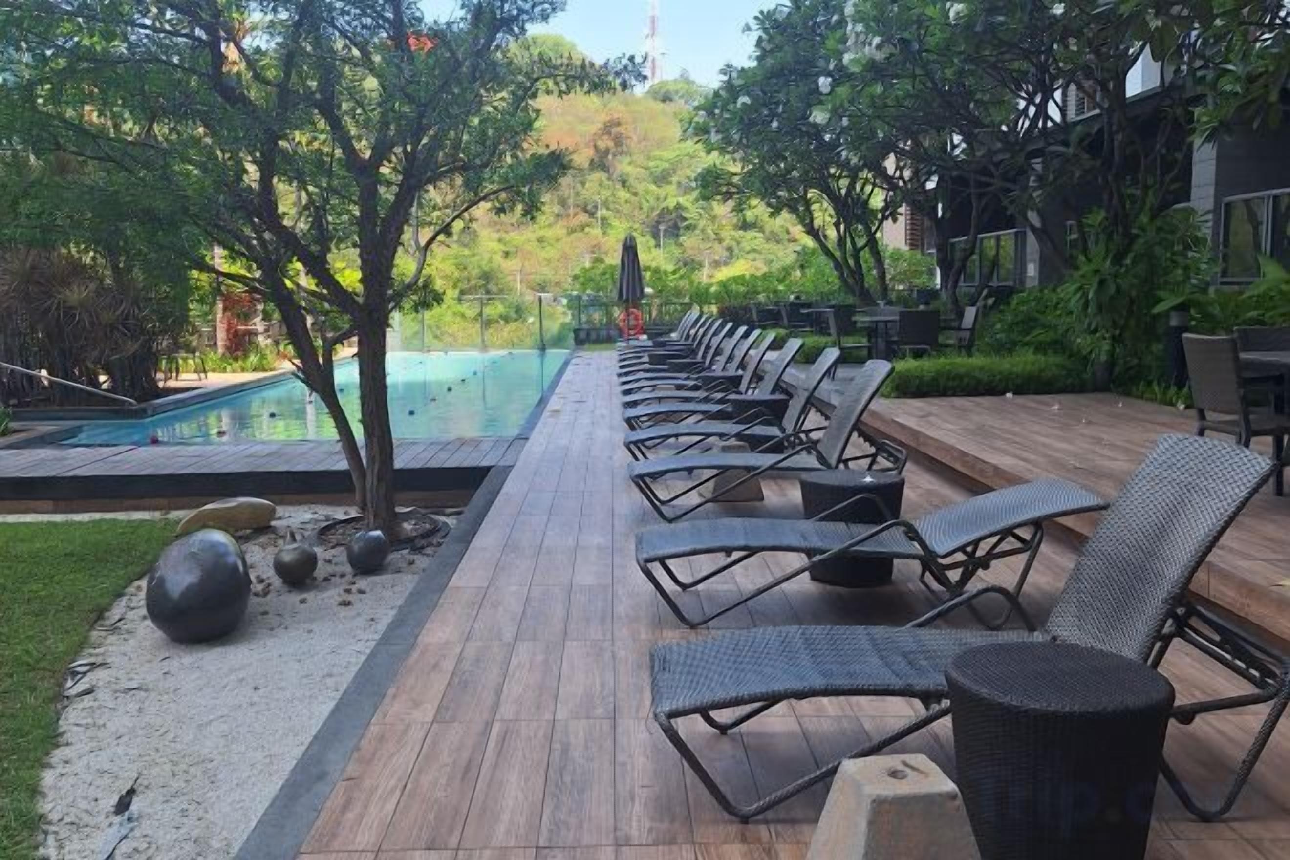 A poolside area with lounge chairs and a pool.