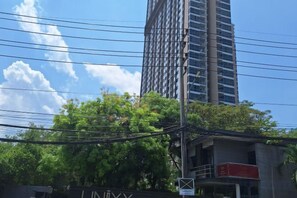 A building with a sign that reads 'LINUXY' and a tree in the foreground. - unixx Seaview Resort (Pattaya)