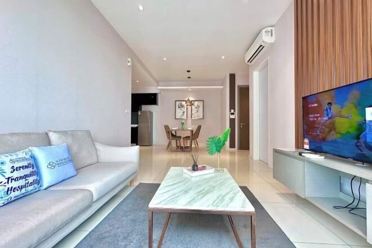 A modern living room with a sofa, a coffee table, and a television.