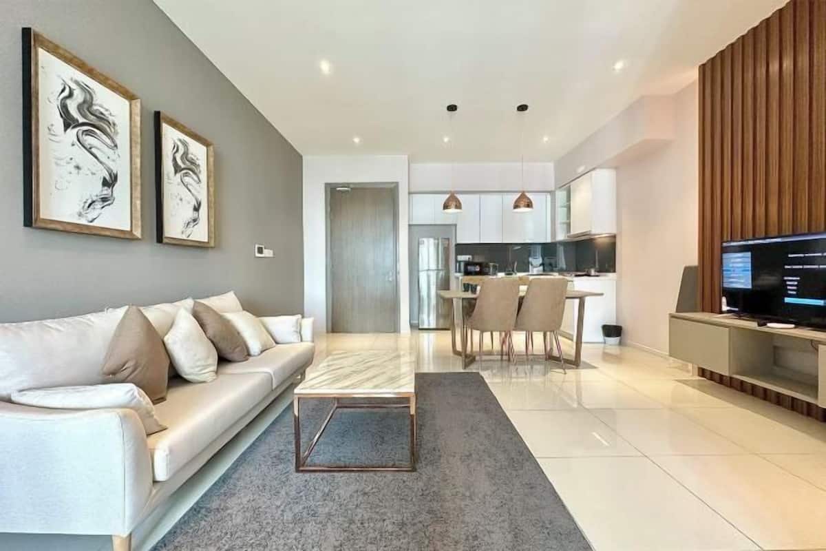 A modern living room with a sofa, coffee table, and artwork on the wall.