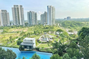A residential complex with high-rise buildings, a central landscaped area, and a swimming pool. - Elysia Park Medini by Stayrene near Legoland (Iskandar Puteri)