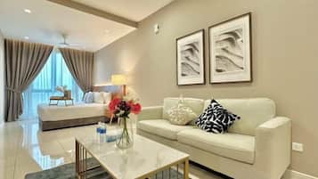 Quarto de hotel com cama, sofá, mesa de centro e obras de arte na parede.
